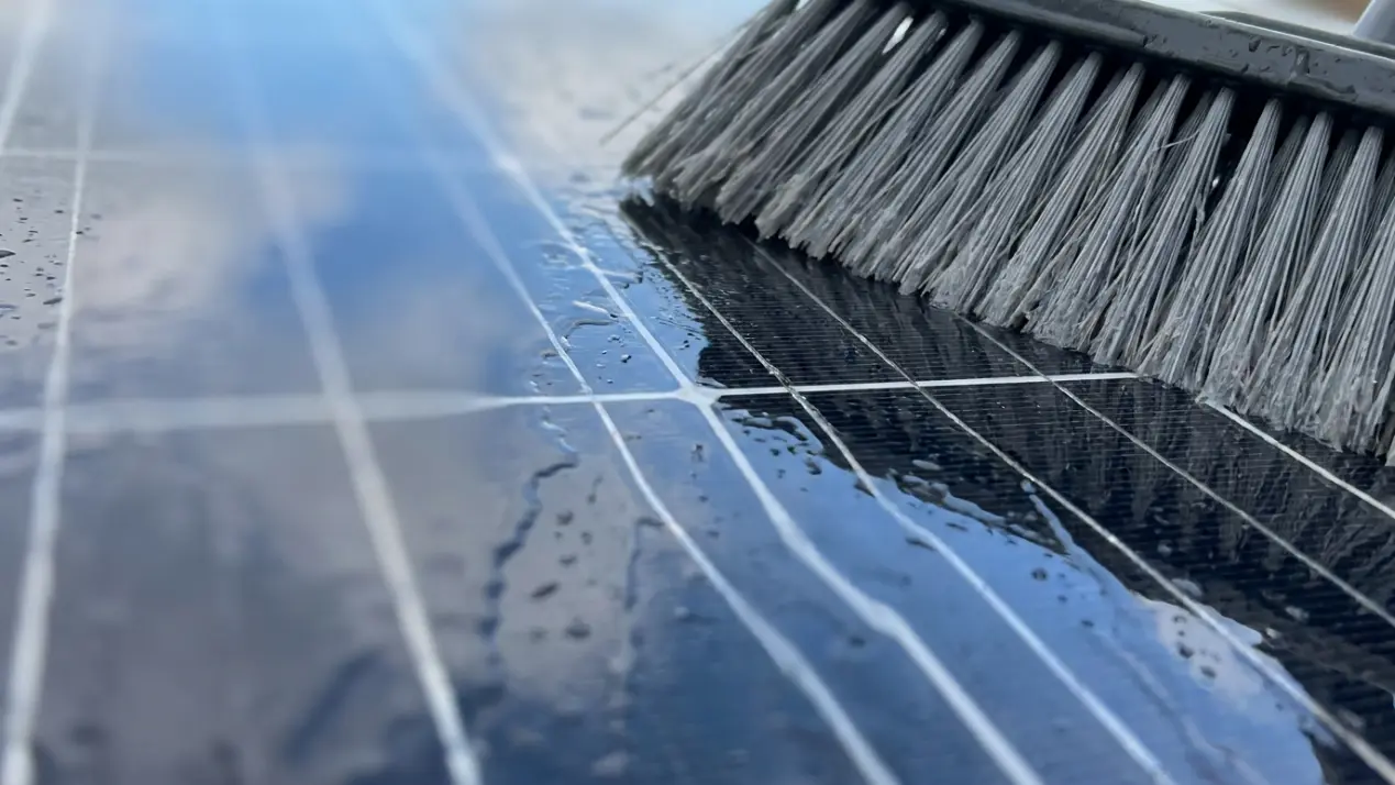 Reinigung eines Solarmoduls mit Wasserbürste — Nahaufnahme