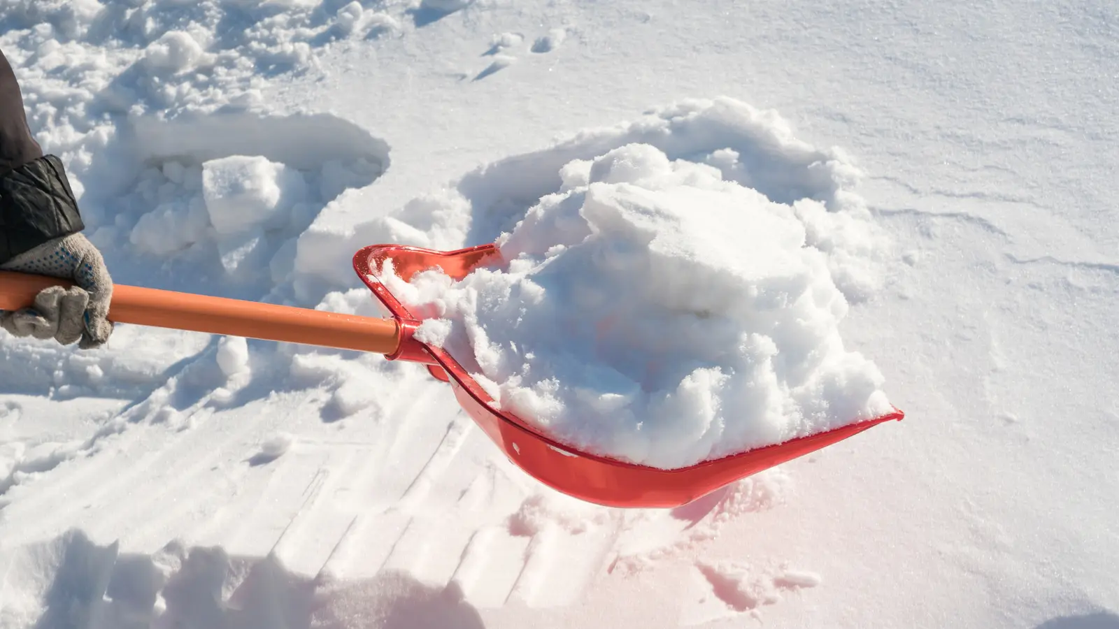 Geräumter Gehweg — Schnee wird mit der Schaufel entfernt