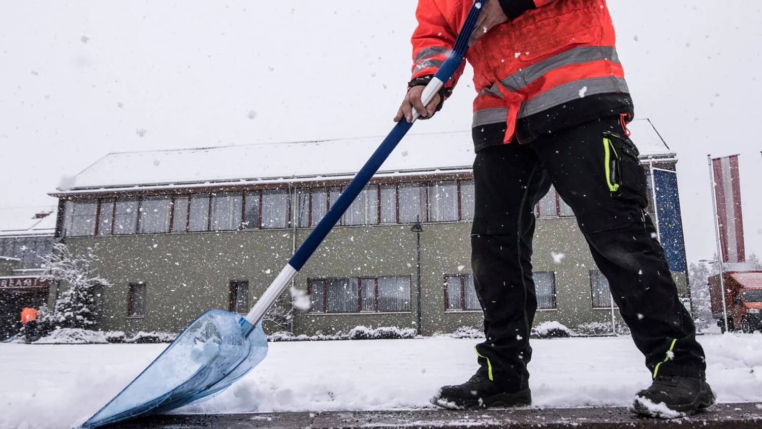 Schneeräumung mit der Schneeschaufel vor einem Objekt in Graz